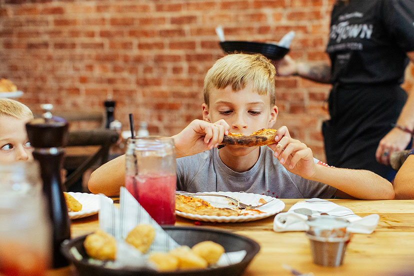 Boy enjoying a slice of P-Town pizza.